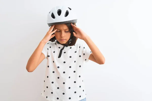 漂亮的小女孩戴着安全的自行车头盔 站在孤立的白色背景之上 双手托着头 因为压力而感到头痛 令人痛苦的偏头痛 — 图库照片