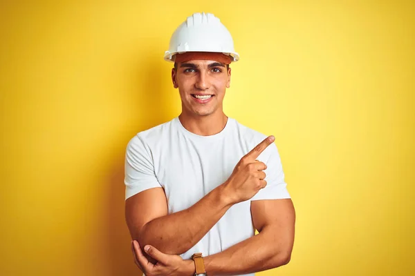 Junger Gutaussehender Mann Mit Bauhelm Über Gelbem Hintergrund Mit Einem — Stockfoto