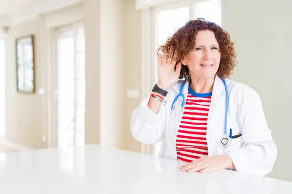 Oudere Doktersvrouw Een Medisch Gewaad Kliniek Glimlachend Met Hand Oor — Stockfoto