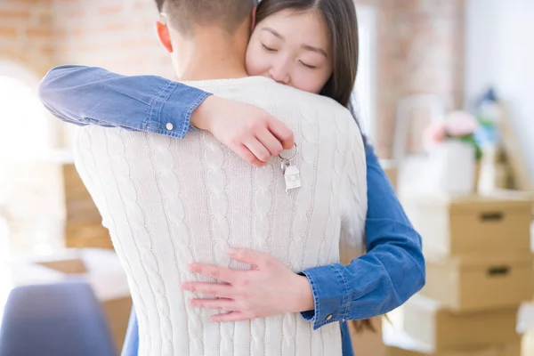 Joven pareja asiática sosteniendo llaves de nueva casa, sonriendo feliz y — Foto de Stock
