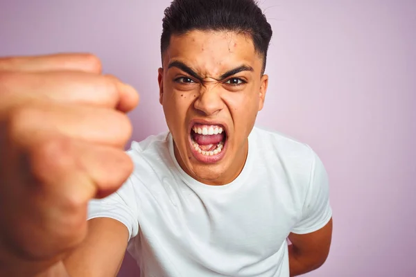 Tシャツを着た若いブラジル人男性がピンクの背景に立っていらいらし 怒りで叫んで 狂気と大声で手を上げ 怒りの概念 — ストック写真