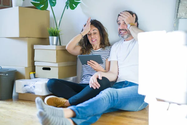 Middle Age Senior Couple Moving New Home Using Tablet Stressed — Stockfoto