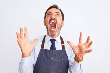 Orta yaşlı esnaf önlük giyip izole edilmiş beyaz arka planda dikiliyor deli deli deli bağırıyor ve bağırıyor agresif bir ifade ve kollar havada. Hayal kırıklığı konsepti.