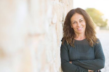 Orta yaşlı güzel bir kadın gülümsüyor. 