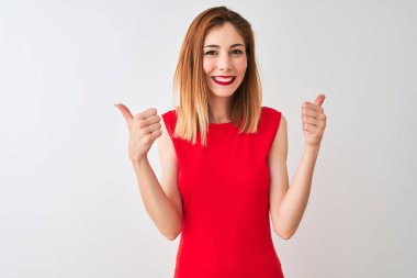 Kırmızı elbiseli, zarif kırmızı elbiseli bir iş kadını izole edilmiş beyaz arka plan başarısı tabelasının üzerinde duruyor. Elleriyle olumlu jest yapıyor, gülümsüyor ve mutlu. Neşeli ifade ve kazanan jest.