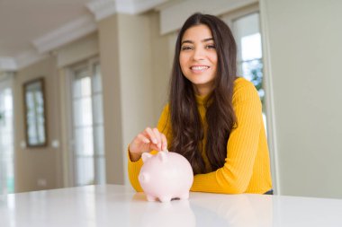 Kadın gibi Piggy banka içinde bir sikke koyarak gülümseyen yakın