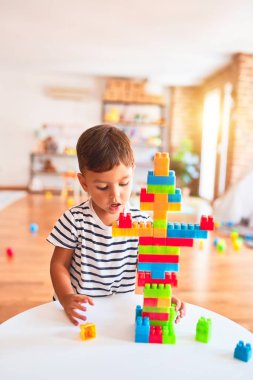 Güzel çocuk anaokulunda inşaat bloklarıyla oynuyor.