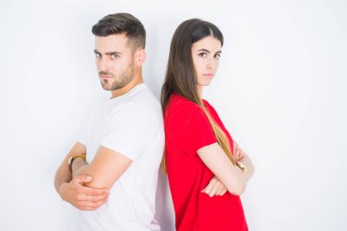 Beyaz izole arka plan üzerinde birlikte genç güzel çift şüpheci ve sinir, kesişmiş kollar ile yüz üzerinde ifade onaylamıyor. Negatif kişi.