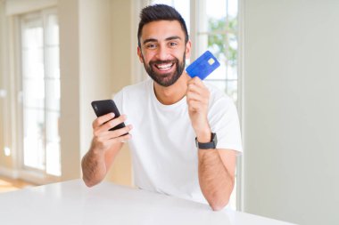 Akıllı telefon ile online ödemek için kredi kartı kullanarak yakışıklı adam