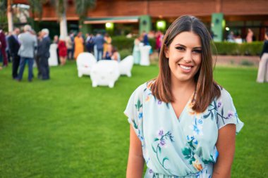 Genç, güzel ve zarif bir kadın. Gelinliği ile mutlu ve neşeli gülümsüyor.