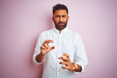 Genç Hintli iş adamı zarif bir gömlek giyer ve pembe arka planda kalır. İfadelerden iğrenir ve tiksinir. Çünkü tiksinti tepki verir. Eller havada. Can sıkıcı bir kavram..