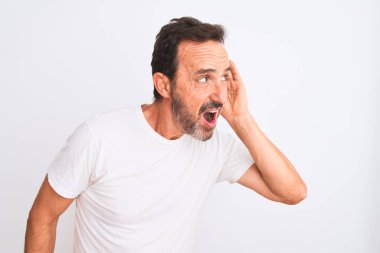 Orta yaşlı yakışıklı bir adam, izole edilmiş beyaz arka plan üzerinde dikilmiş dedikodu ya da dedikodulara kulak misafiri olarak gülümsüyor. Sağırlık kavramı.