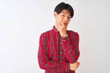 İzole edilmiş beyaz arka plan üzerinde duran sıradan kırmızı tişörtlü genç Çinli adam çapraz kollar ve çeneyle gülümseyen kameraya bakıyor. Olumlu düşünüyorum..