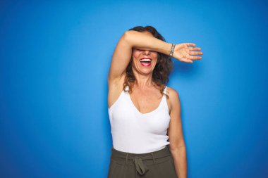 Orta yaşlı, kıvırcık saçlı, mavi arka planda duran neşeli ve komik kollarıyla gözlerini kapatan son sınıf öğrencisi. Kör kavram.