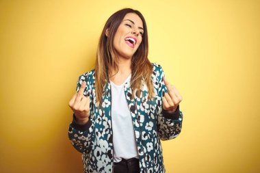 Sarı arka plan üzerine gündelik ceket giyen genç ve güzel bir kadın orta parmağını göstererek kötü ifade, provokasyon ve kaba tavır sergiliyor. Heyecanlı çığlık