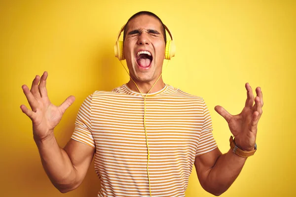 Νεαρός Όμορφος Άντρας Που Χρησιμοποιεί Ακουστικά Πάνω Από Κίτρινο Απομονωμένο — Φωτογραφία Αρχείου