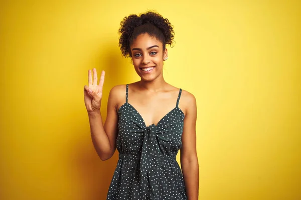 穿着夏装的非洲裔美国女人穿着休闲服 披着孤立的黄色背景 带着自信和快乐的笑容 用第三号手指指指着 — 图库照片