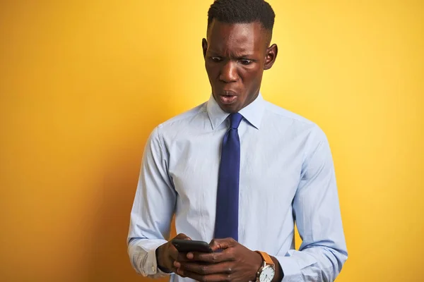 Afroamerikansk Affärsman Med Smartphone Står Över Isolerad Gul Bakgrund Rädd — Stockfoto