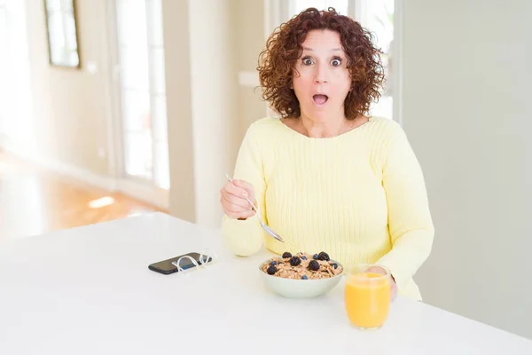 高龄妇女早上在家吃健康早餐 吓得吓了一跳 脸上露出惊讶的一面 害怕和兴奋的用恐惧的表情 — 图库照片