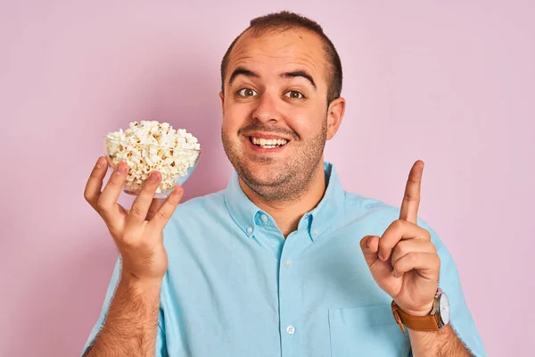 Jongeman Met Kom Met Popcorn Geïsoleerde Roze Achtergrond Verrast Met — Stockfoto