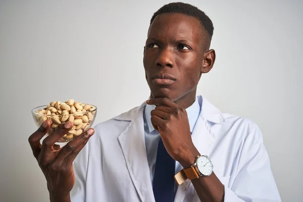 Africano Americano Doctor Hombre Celebración Bowl Con Pistachos Sobre Aislado —  Fotos de Stock