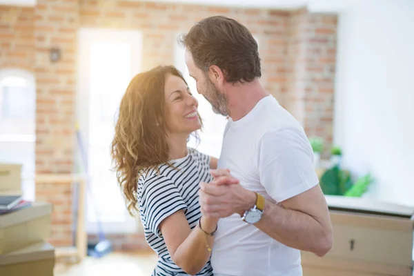 Pareja mayor de mediana edad mudándose a una nueva casa, bailando y sonriendo — Foto de Stock