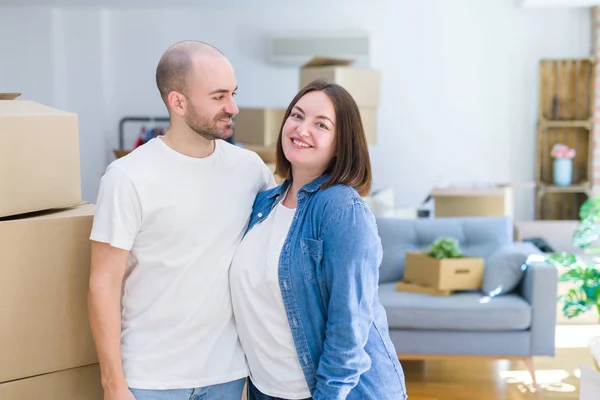 Молодая пара вместе улыбается счастливо переезжая в новый дом — стоковое фото