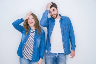 Genç ve güzel bir çift, beyaz izole edilmiş arka planda el ele tutuşup hata yaptıklarını hatırlayarak şaşırdılar. Unuttum, kötü hafıza konsepti.