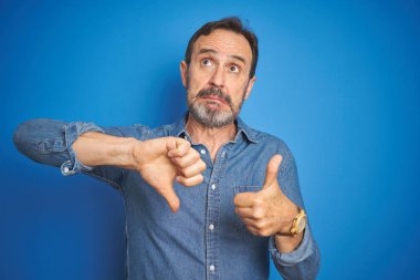 Gri saçlı, mavi geçmişi olan yakışıklı, orta yaşlı bir adam. Baş parmaklarını yukarı aşağı hareket ettiriyor. Anlaşmazlık ve anlaşma ifadesi. Çılgın çatışma