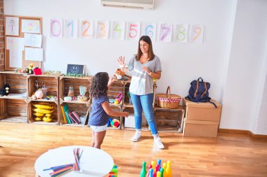 Anaokulunda oynayan küçük kıza matematik öğreten güzel bir öğretmen.