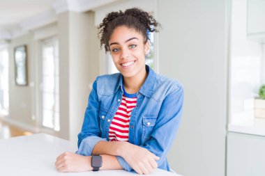 Yüzünde mutlu ve güzel bir gülümseme ile rahat denim ceket giyen afro saçlı güzel genç Afro-Amerikan kadın. Şanslı kişi.