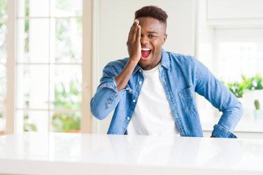 Yakışıklı afro-amerikan adam evde bir gözünü kendine güvenen bir gülümseme ve sürpriz bir duygu ile kapatıyor..