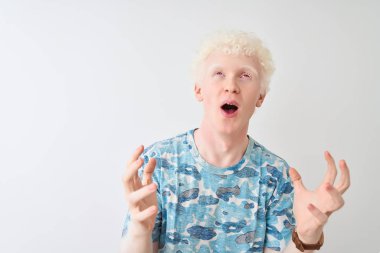 Genç albino sarışın adam rahat t-shirt izole beyaz arka plan deli ve deli bağırarak ve agresif ifade ve kollar kaldırdı ile bağırıyor üzerinde duran giyiyor. Hayal kırıklığı kavramı.