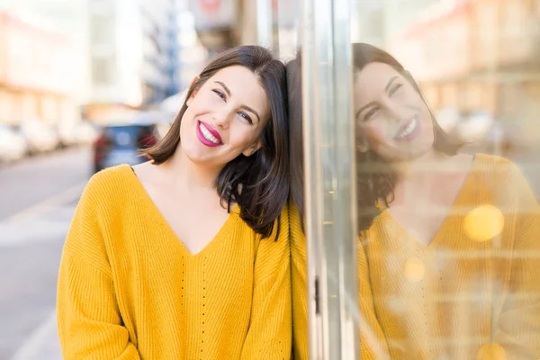 Krásná mladá žena usmívající se sebevědomě a vesele se opírá o — Stock fotografie