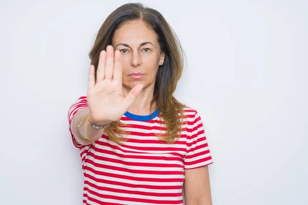 中年妇女站在白人孤立无援的背景上 用手掌停止歌唱 脸上带有消极而严肃的手势的警告表情 — 图库照片