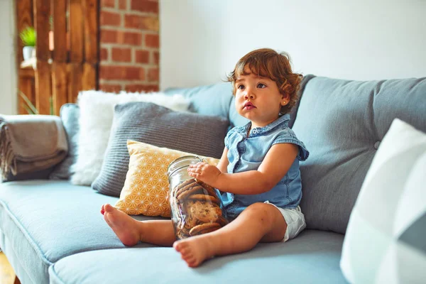 Menina Criança Bonita Segurando Frasco Biscoitos Sentados Sofá — Fotografia de Stock