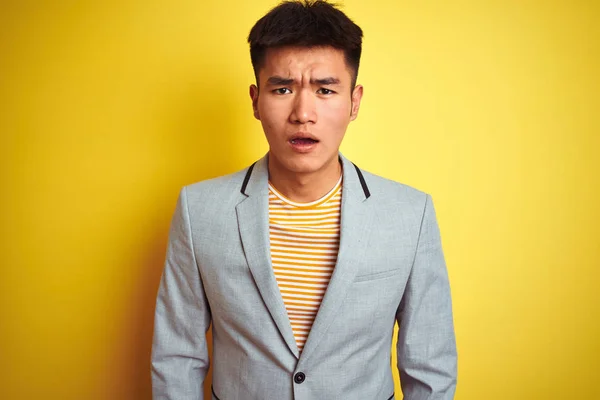 孤立した黄色の背景の上に立ってジャケットを身に着けている若いアジアの中国のビジネスマンは恐れて 驚きの表情でショックを受けました 恐怖と興奮した顔 — ストック写真
