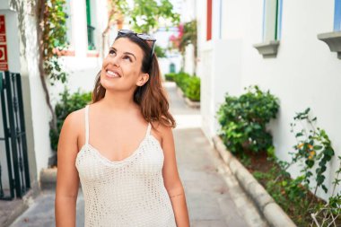 Puerto de Mogan 'ın renkli köyünde genç ve güzel bir kadın. Yaz tatilinde sokakta mutlu bir şekilde gülümsüyor.