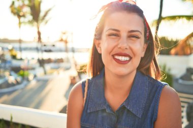 Genç, güzel bir kadın mutlu bir şekilde gülümsüyor. Güneşli bir yaz gününde Tenerife, Puerto de la Cruz sokaklarında yürüyor.