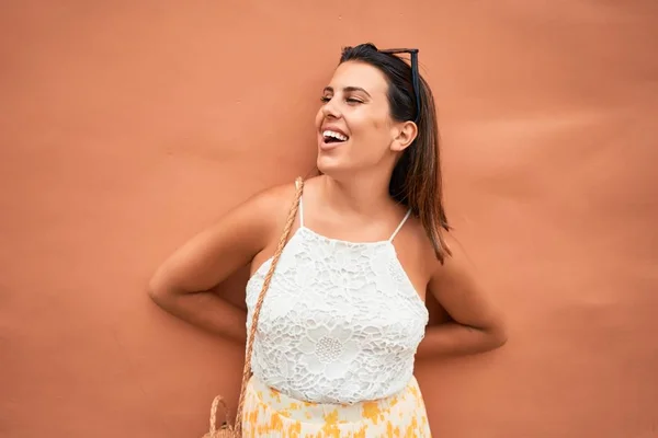 Piękna Dziewczyna Opierająca Się Pomarańczowej Ścianie Młoda Przyjazna Kobieta Uśmiechająca — Zdjęcie stockowe