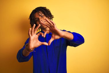 Sarı arka plan üzerinde mekanik üniforma giyen Afro işçi elleri ile kalp sembolü şeklinde aşk yaparken gülümsüyor. Romantik konsept.