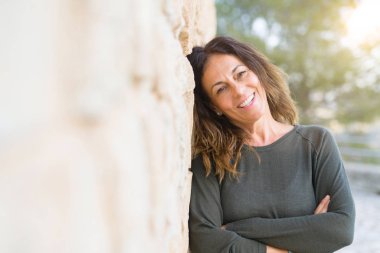 Güzel orta yaş kadın gülümseyen neşeli bir tuğla w üzerine eğilme