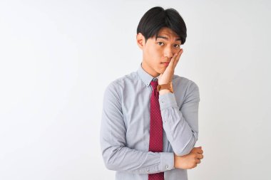 Soyutlanmış beyaz arka planda duran zarif kravat takan Çinli işadamı, çapraz kollarla depresyon sorunlarından sıkılmış ve yorgun göründüğünü düşünüyor..
