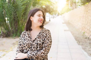 Bahçede mutlu gülümseyen kırmızı dudaklı genç güzel kadın