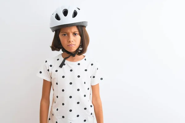 漂亮的小女孩戴着安全自行车头盔 站在孤独的白色背景下 怀疑和紧张 皱着眉头因为问题而难过 消极的人 — 图库照片