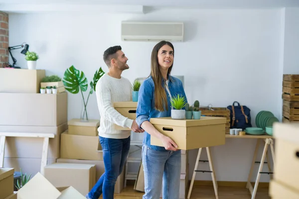 Pareja Joven Mudándose Nuevo Hogar Sonriendo Feliz Sosteniendo Cajas Cartón — Foto de Stock