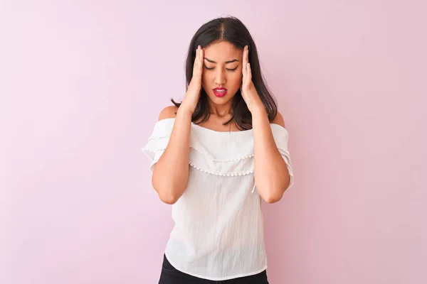 美丽的中国女人穿着白色的T恤 站在孤立的粉色背景之上 手托着头痛苦不堪 因为压力 令人痛苦的偏头痛 — 图库照片