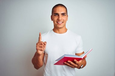 Beyaz izole bir zemin üzerinde kırmızı kitap okuyan genç yakışıklı bir fikir ya da soru işareti ile şaşırdı mutlu bir yüz, bir numara