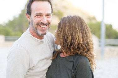 Güneşli bir günde gülümseyen ve sarılarak romantik çift