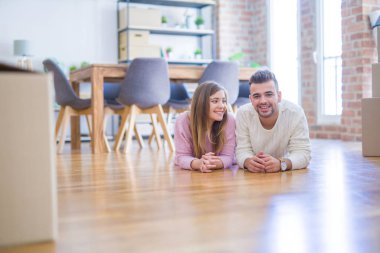 Aşk genç güzel çift yeni bir eve hareket, karton kutular etrafında yerde yatıyor, yeni daire için çok mutlu ve neşeli